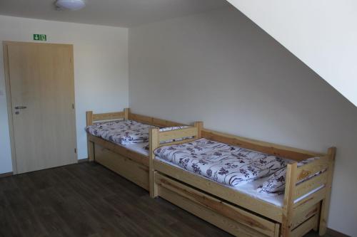 two bunk beds in a room with a staircase at Buchtův statek in VendolÃ­