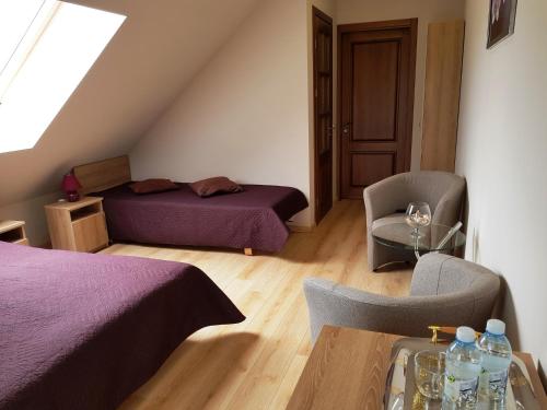 una camera con due letti, un tavolo e una sedia di "Trakaitis" apartments in Villa a Trakai