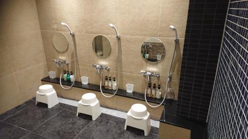 baño con 4 espejos y una fila de lavabos en R's Forest Inn, en Kawasaki