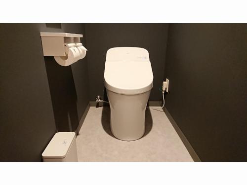 a bathroom with a white toilet in a stall at R's Forest Inn in Kawasaki