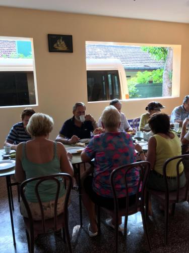 a group of people sitting at tables in a room at Sunny Lanka Guest House in Matara