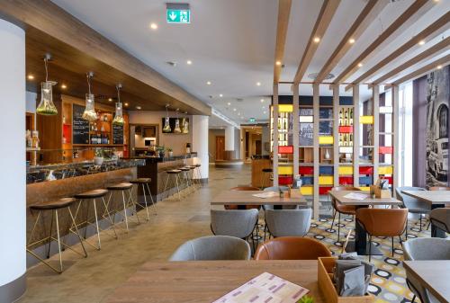 a restaurant with tables and chairs and a bar at Mercure Hotel Stuttgart Gerlingen in Gerlingen