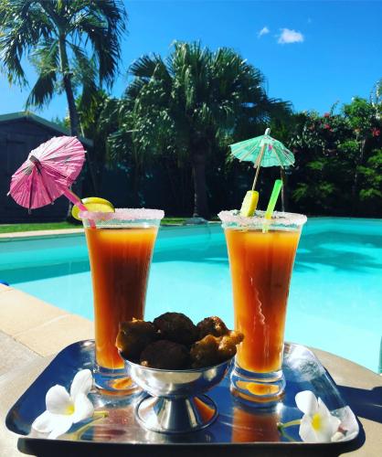 two drinks on a tray next to a pool at Gites Kaladja in Port-Louis