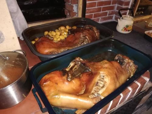 two trays with chickens and other food in a oven at Eco Village Under the Cliffs in Ilindentsi