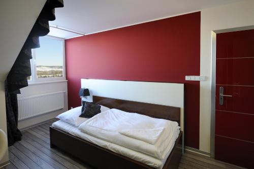 a bedroom with a bed with a red wall at Caramell in Louny