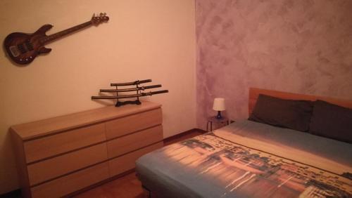 una camera con un letto e una chitarra appesa al muro di Attico a Barberino di Mugello a Barberino di Mugello