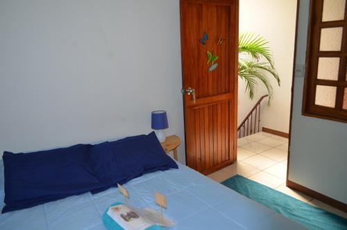 a bedroom with a blue bed with a book on it at Guesthouse Casa Lapa in Alajuela City