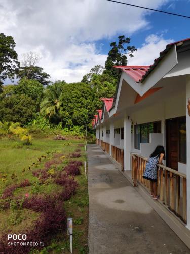 a woman standing on a balcony of a building at Hotel Exotica Squares in Neil Island