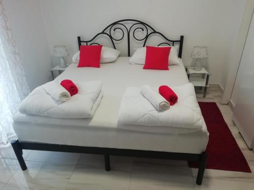 a large white bed with red pillows on it at Room Dragica in Dubrovnik