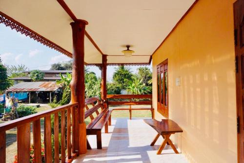 - un balcon d'une maison avec un banc dans l'établissement บ้านเรือนทอง, à Chiang Khan