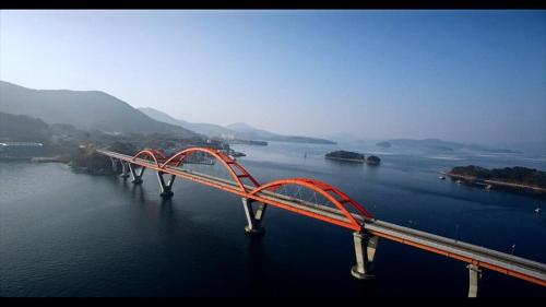 a long red bridge in the middle of the water at Geoje Seaside Luxury Family Villa in Geoje 