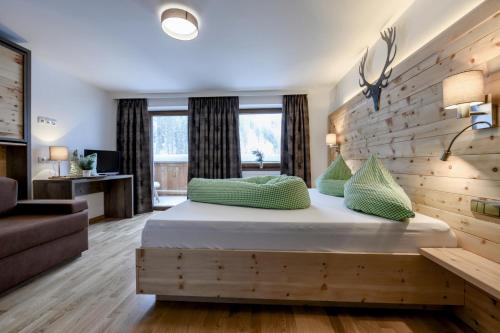 Berghotel Gerlosstein في هينزنبرغ: غرفة نوم بسرير وجدار خشبي