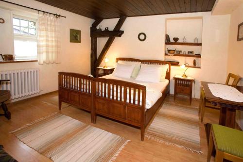 a bedroom with a wooden bed with white pillows at Pension Brusenka in Bystřice pod Hostýnem