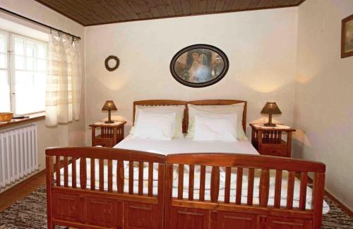 a bedroom with a large wooden bed with two lamps at Pension Brusenka in Bystřice pod Hostýnem