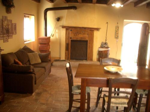 a living room with a table and a couch at Antica Dimora dell'Ortolano in Castellaro