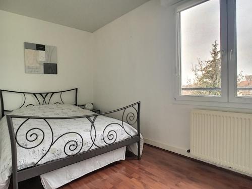 a bedroom with a bed and a window at Echapée belle proche gare et centre ville in Chalons en Champagne