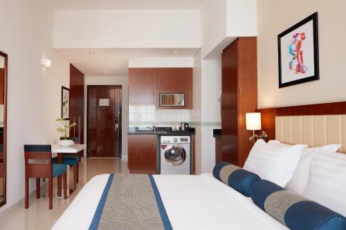 a hotel room with a bed and a kitchen at Treppan Hotel & Suites By Fakhruddin in Dubai