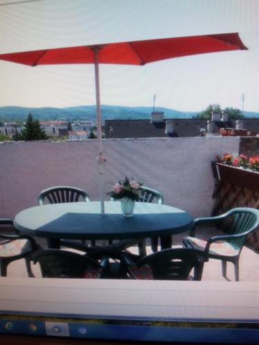 a table and chairs with an umbrella on a patio at TÖRÖK VENDÉGHÁZ in Sopron