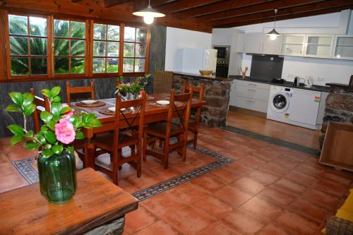 a kitchen and dining room with a table and chairs at Solar Arco de São Jorge in Santana