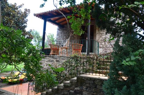 a stone house with chairs and a porch at Solar Arco de São Jorge in Santana