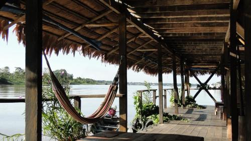 a porch with hammocks and a view of the water at Cabaña Flotante Kurupira in Leticia