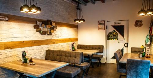 a restaurant with wooden tables and chairs and a brick wall at Burnout Wildalps in Wildalpen