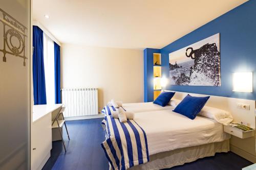 
a bedroom with a blue and white bed and a blue wall at Ur-Alde in San Sebastián
