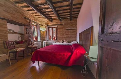 a bedroom with a large red bed in a room at Countryhouse Montebello in Grottazzolina