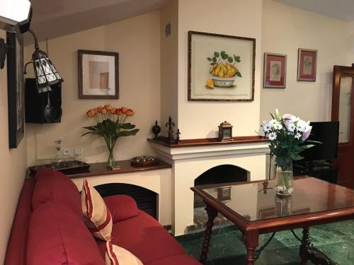 a living room with a red couch and a fireplace at LA ATALAYA GREAT LUXURY ATTIC in Antequera