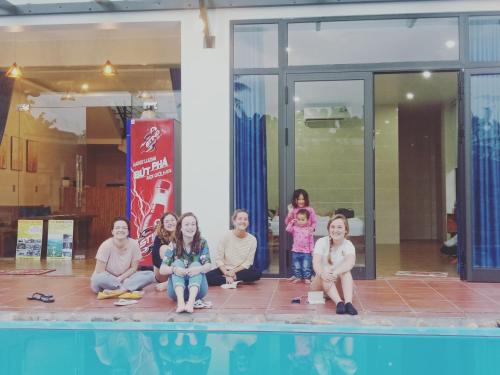 a group of women sitting next to a swimming pool at Hugo Homestay in Phong Nha