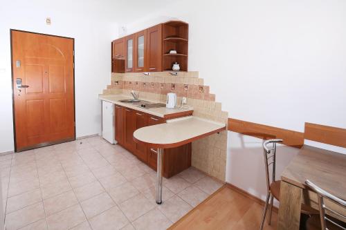 a small kitchen with a sink and a table at 100-SIO Apartamenty in Kołobrzeg