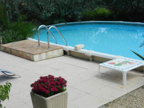 a pool with a bench and flowers next to it at L'Oliveraie in Draguignan