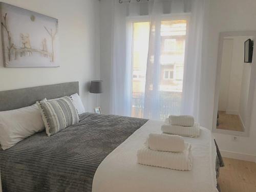 a bedroom with a bed with towels on it at EXCLUSIVO Y LUMINOSO PISO EN EL PARQUE DEL RETIRO in Madrid