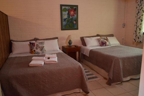 1 dormitorio con 2 camas y toallas. en Oasis Bed and Breakfast en Puerto Iguazú