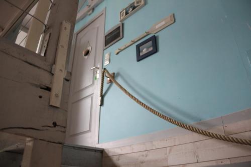 a door with a rope attached to a wall at Le Ch'tipanier in Morcenx
