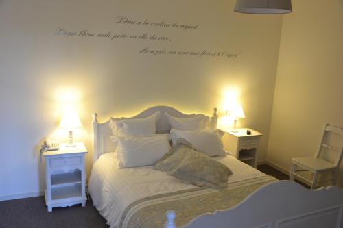a bedroom with a bed with a quote on the wall at Hotel La Villa Julia in Agon-Coutainville