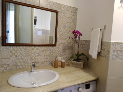 bagno con lavandino e specchio di Una Scala Dal Centro a Agrigento