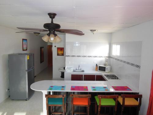 a kitchen with a table and chairs and a ceiling fan at Apartamentos Rocky Cay Bay in San Andrés