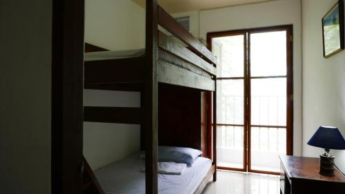 een slaapkamer met een stapelbed, een bureau en een raam bij JSB Residences Cebu A-flat in Tugbongan