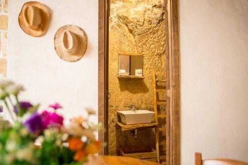 a mirror in front of a sink in a bathroom at Si-Moutique, le Case-grotte degli Avi 2 in Modica
