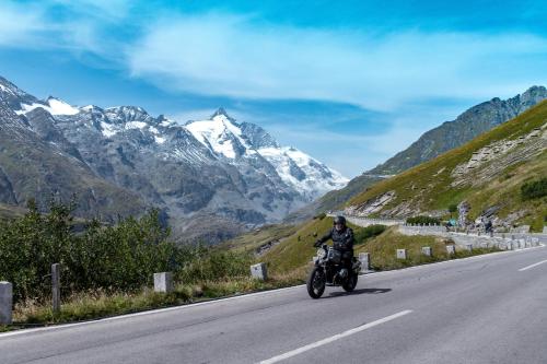a man riding a motorcycle down a mountain road at Ferienwohnungen Panorama Harrys Bike Tours in Villach