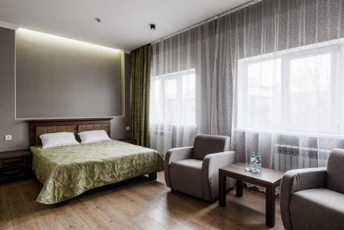a bedroom with a bed and a chair and a window at Nova Hotel in Astrakhan