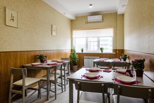 una sala da pranzo con tavoli, sedie e una finestra di Nova Hotel ad Astrakhan