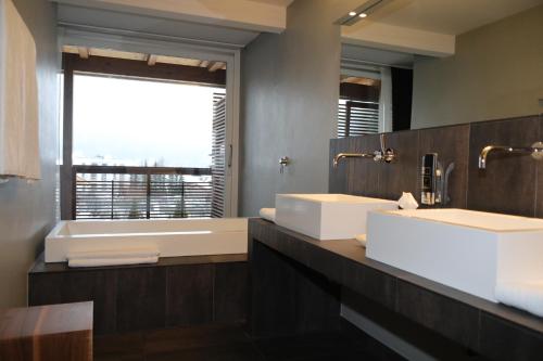a bathroom with two sinks and a large mirror at Feldmilla Design Hotel - Wellness & SPA in Campo Tures