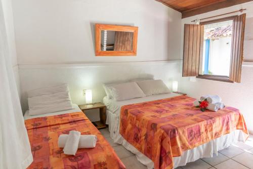 a bedroom with two beds and a window at Pousada Varanda do Sol in Arraial d'Ajuda