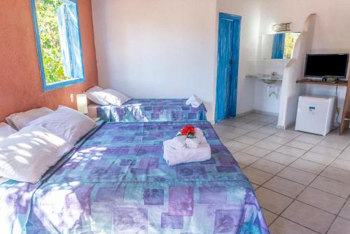 a bedroom with a bed with a stuffed animal on it at Pousada Varanda do Sol in Arraial d'Ajuda