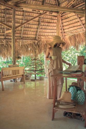 a woman in a straw hat standing under a table with a laptop at El Valle Lodge in El Valle