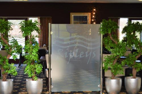 a group of potted plants in front of a glass door at Padbrook Park Hotel in Cullompton