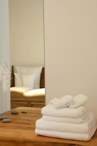a stack of white towels sitting on a floor next to a mirror at Julius in der Pfalz in Hainfeld