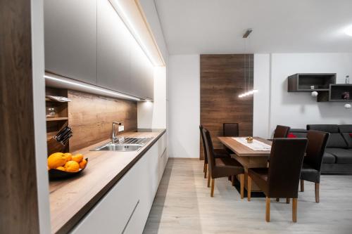 - une cuisine et une salle à manger avec une table et des chaises dans l'établissement APARTMA KATKA Vila Mojca, à Kranjska Gora